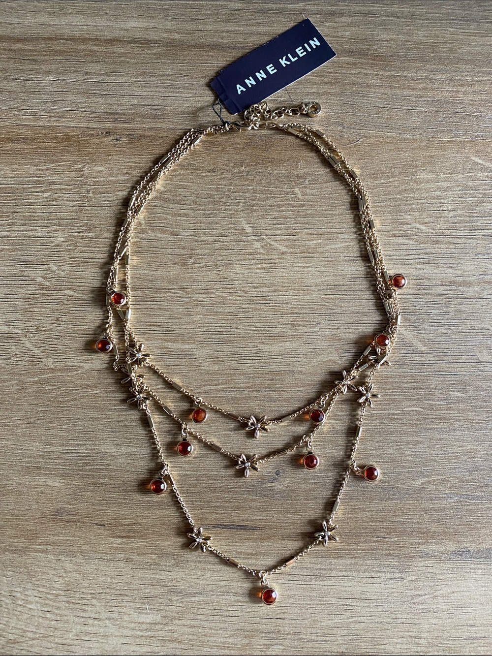 Anne Klein three tiered gold colored with flower and crystal details necklace